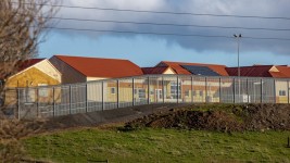 The buildings of the Ashley Youth Detention Centre sit behind a tall fence.